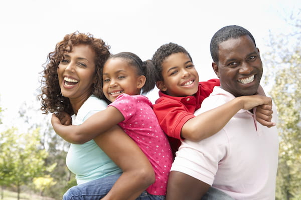 A black family laughs together happily, illustrating that Susan Gonzales helps families.