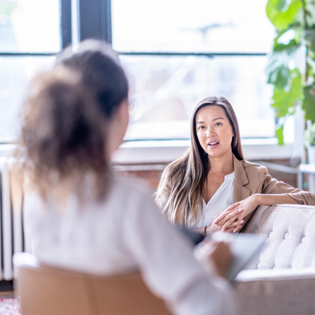 Two women talking in a therapy setting, this image is used to support the benefits of therapy associates
