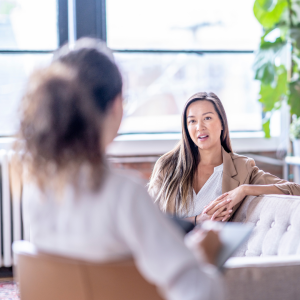 Two women talking in a therapy setting, this image is used to support the benefits of therapy associates 