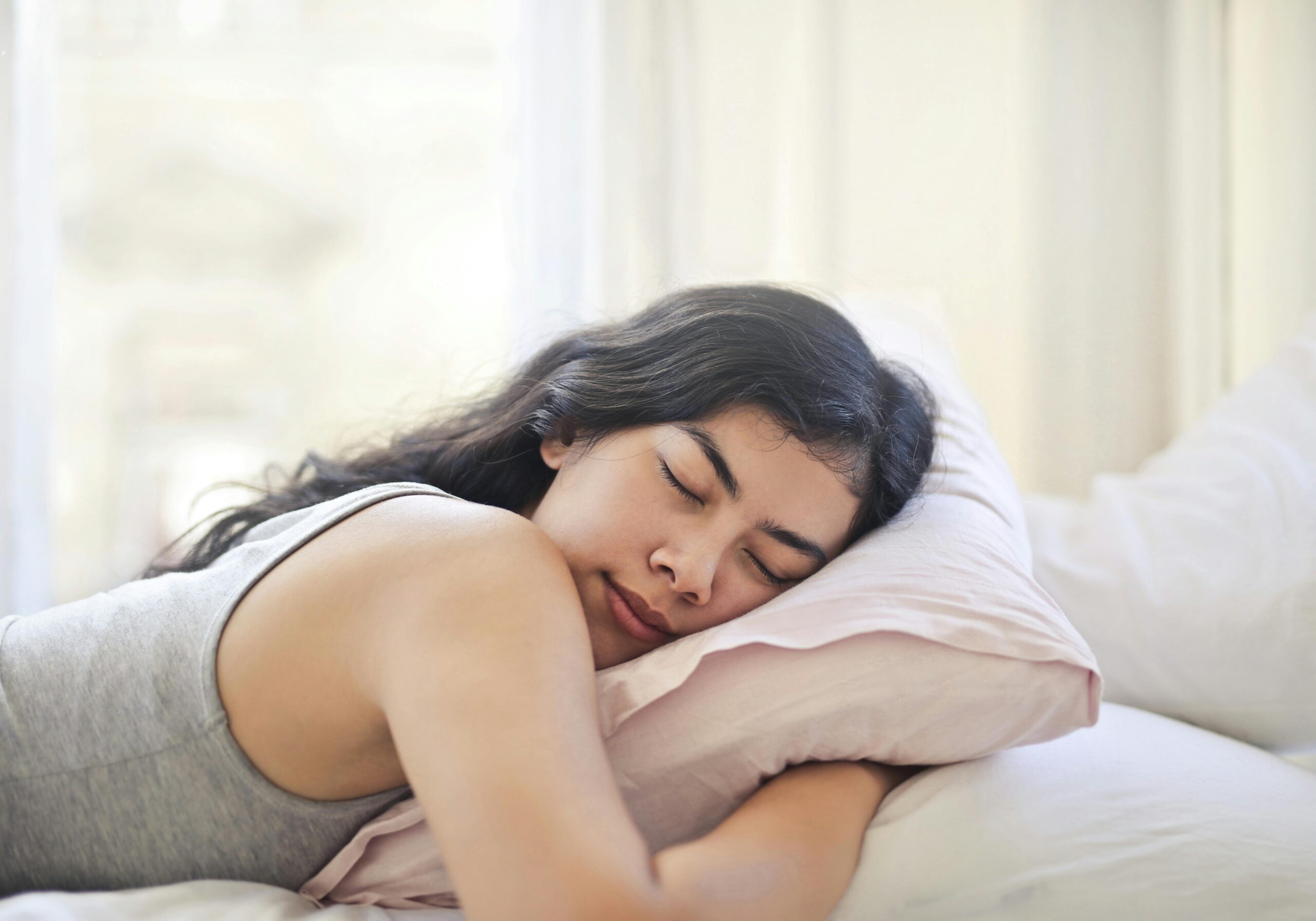 woman sleeping with her hands under her pillow